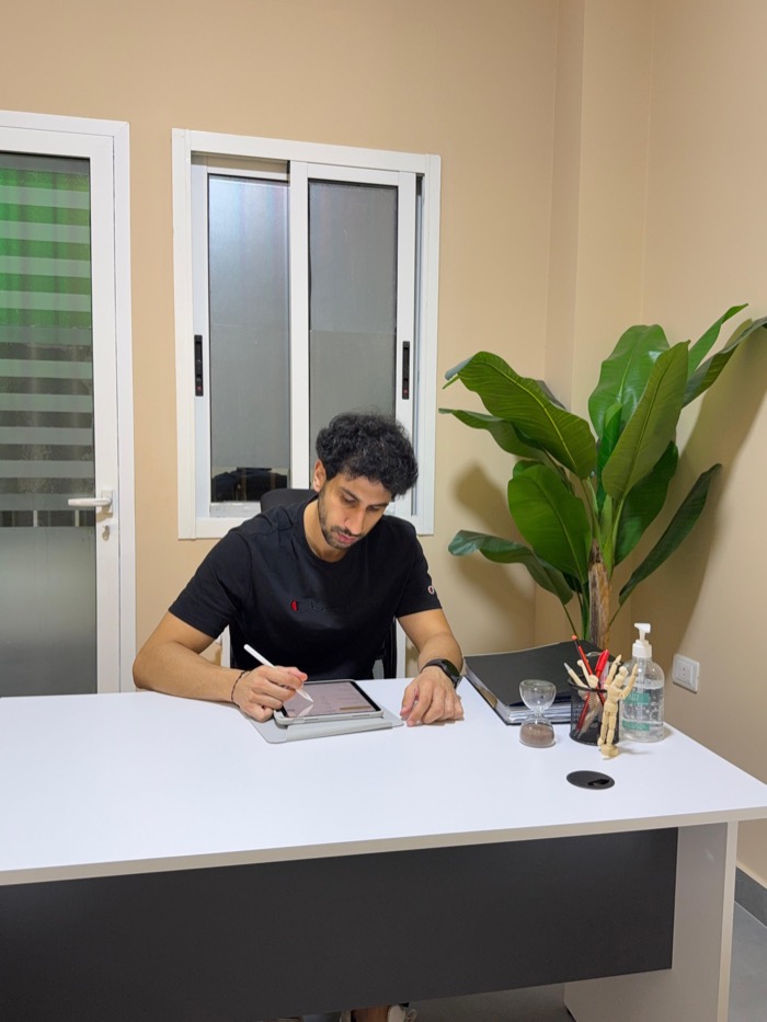 Mark Nourieh writing a treatment plan at his desk in the clinic